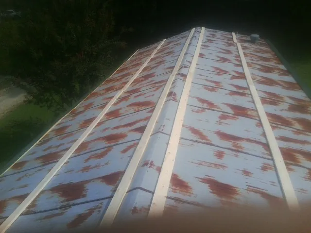 Rusted metal roof panels with new wood purlins before replacement — Storm Damage Roof Repair in Cohutta by Roofing Brothers