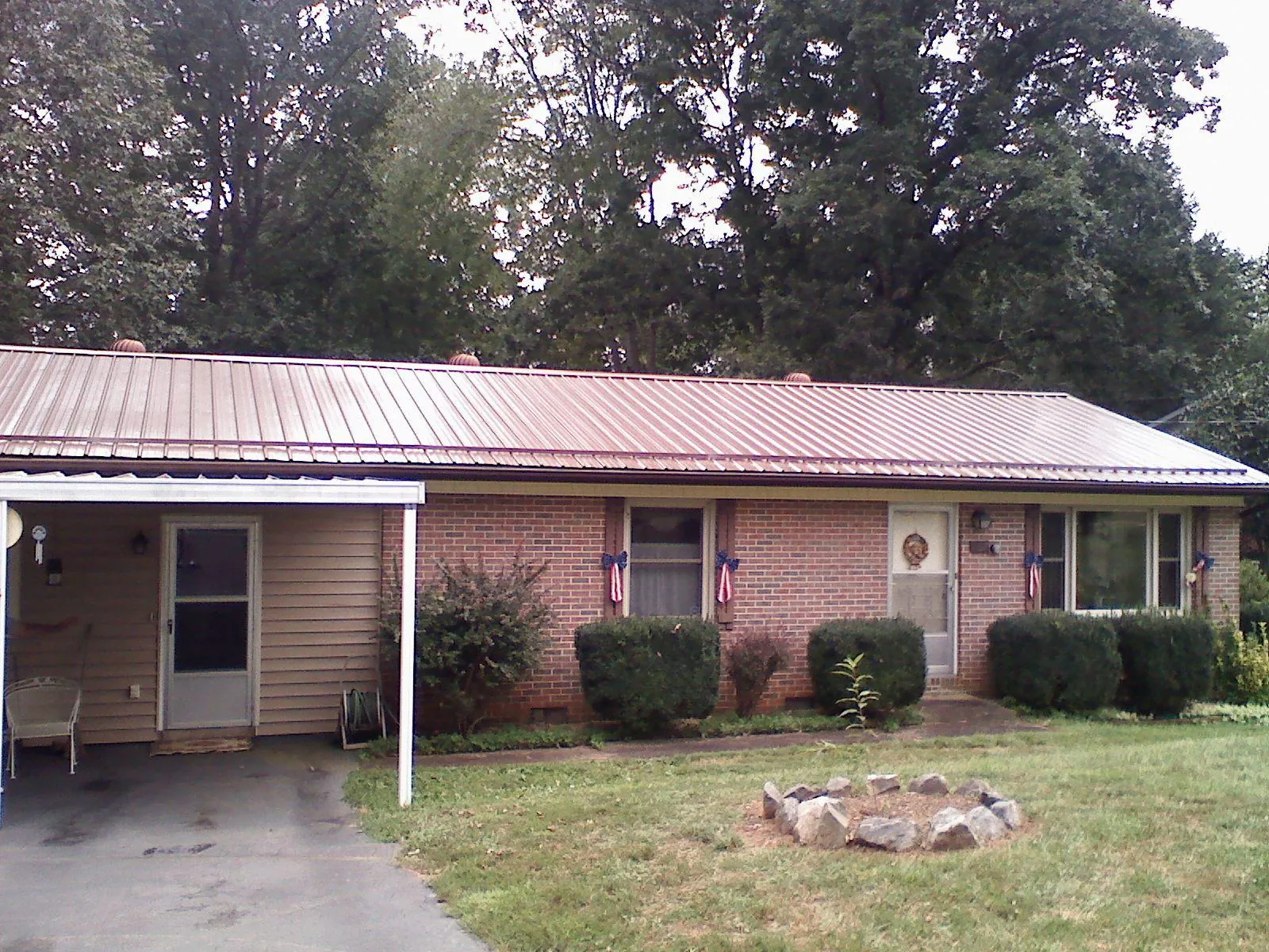 Bronze metal roof and carport on a brick ranch home — Roof Repair work by our crew in Cohutta
